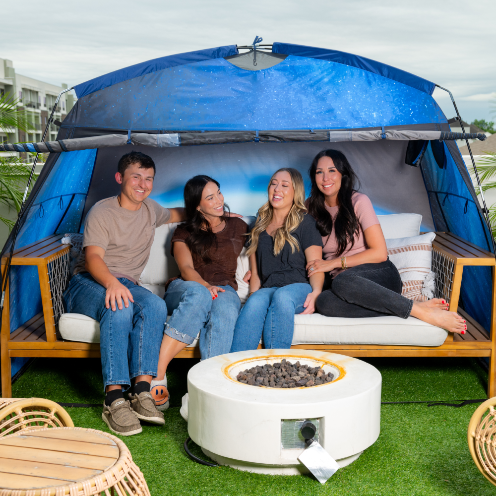 Adult friends hanging out with a MyFort tent set up in the backyard.